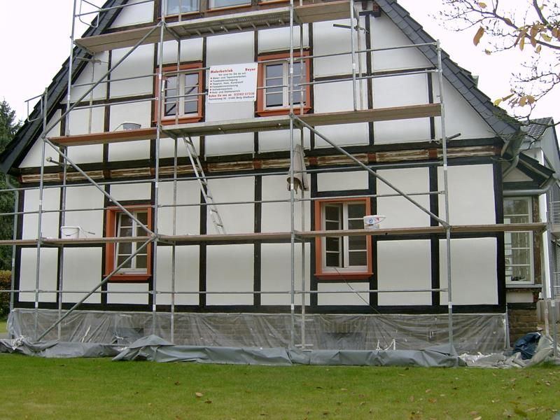 Ein Haus mit Gerüsten darum herum und einem Schild mit der Aufschrift „Gerüst“ darauf