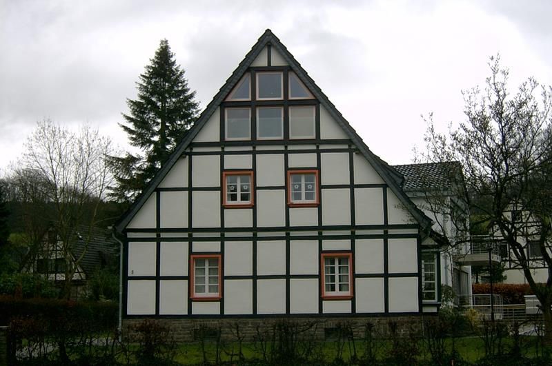 Ein weiß-schwarzes Haus mit einem dreieckigen Dach