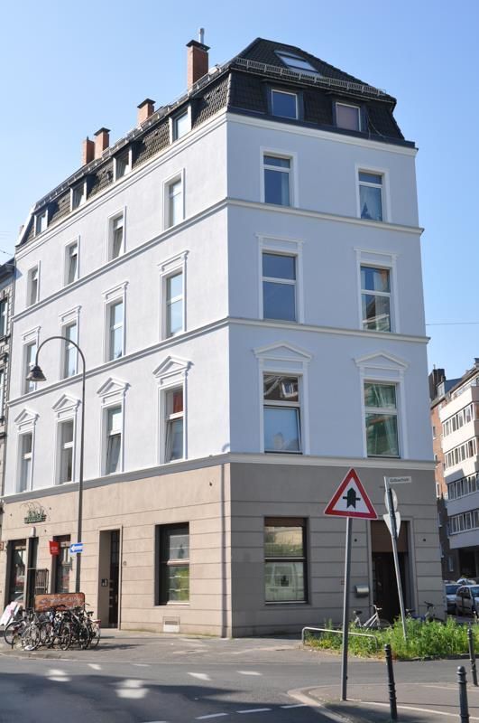 Ein großes weißes Gebäude mit einem dreieckigen Schild davor