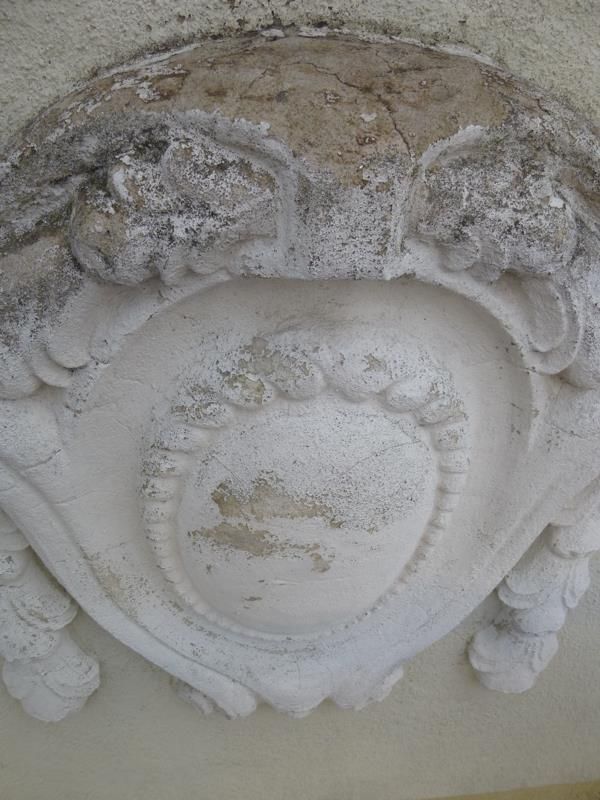 Eine Nahaufnahme einer Skulptur an einer Wand, die wie ein Wappen aussieht