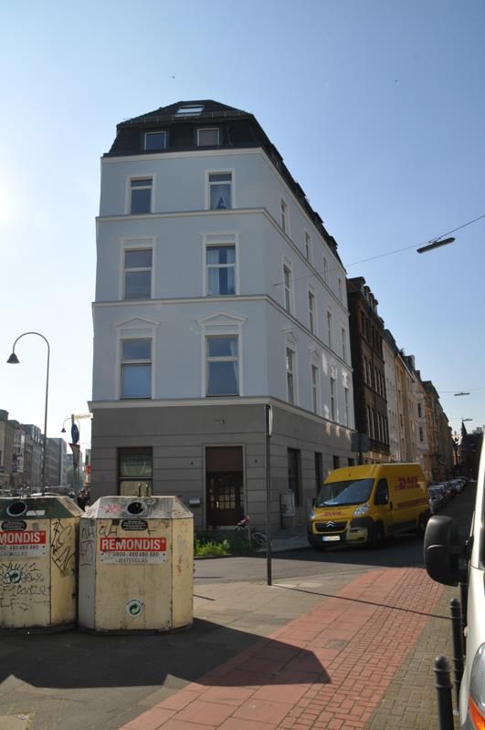 Ein Gebäude, vor dem ein gelber Lieferwagen parkt