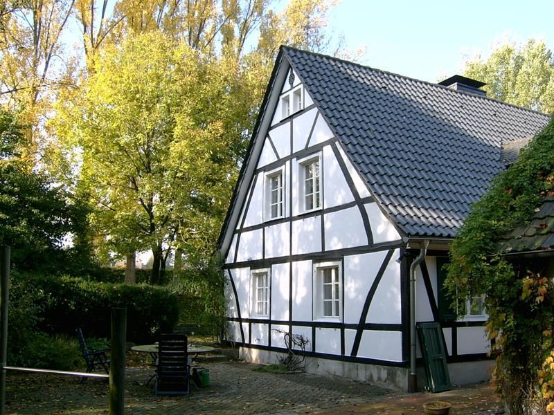 Ein weiß-schwarzes Haus mit einem grauen Dach