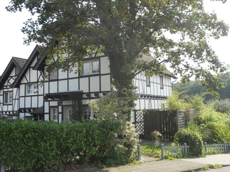 Ein schwarz-weißes Haus mit einem Baum davor