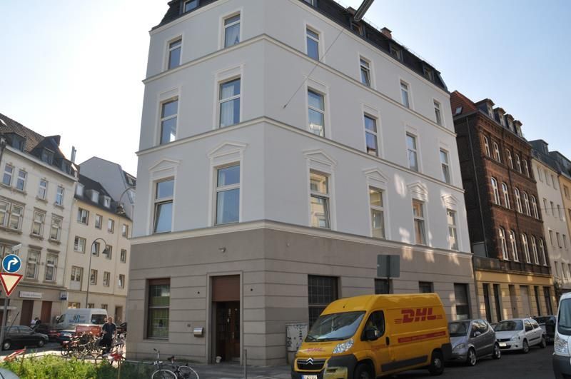 Ein gelber DHL-Transporter steht vor einem Gebäude