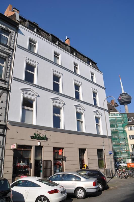 Ein weißes Gebäude mit davor geparkten Autos