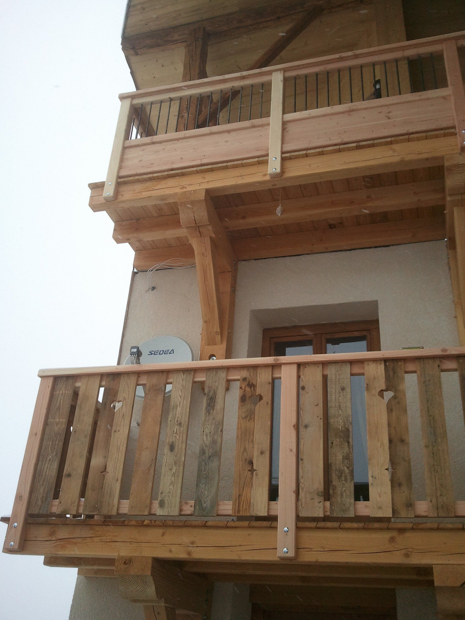 Coin d'un bâtiment avec plusieurs balcons en bois