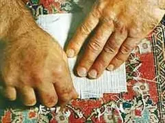 Eine Nahaufnahme der Hände einer Person, die ein Stück Papier hält.