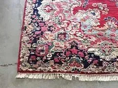 Eine Nahaufnahme eines Teppichs auf einem Betonboden.