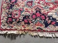 Auf dem Boden liegt ein bunter Teppich mit Blumenmuster.