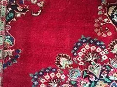 Eine Nahaufnahme eines roten Teppichs mit einem Blumenmuster.