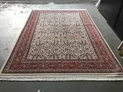 In einem Raum liegt ein Teppich auf einem Betonboden.