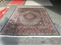 Auf einem Betonboden liegt ein großer Teppich.