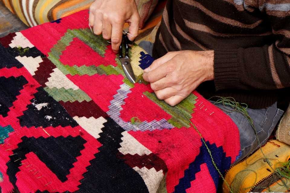 Eine Person schneidet ein Stück Stoff mit einer Schere