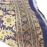 Eine Nahaufnahme eines blau-goldenen Schals mit Blumenmuster.