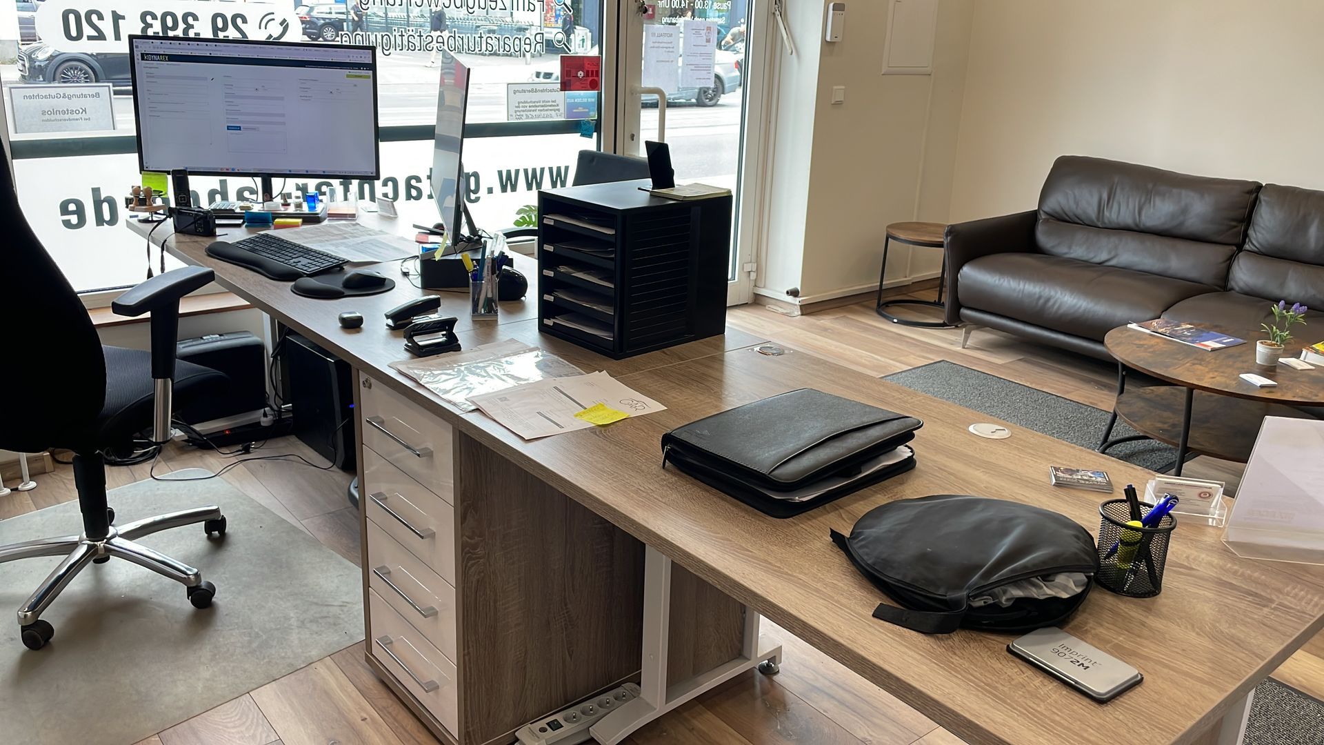 Ein Wohnzimmer mit einer Couch und einem Schreibtisch mit einem Computer darauf