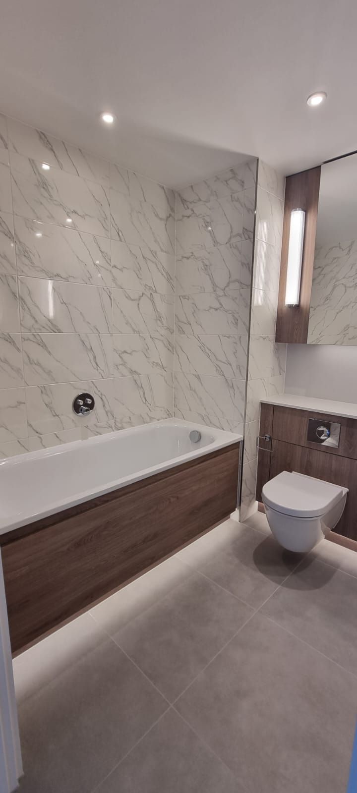 Un baño con bañera, inodoro y espejo.