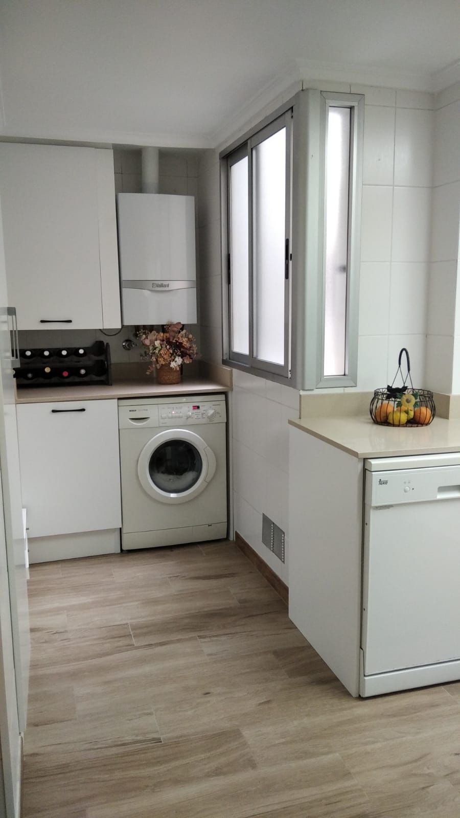 Una cocina con lavadora, secadora y lavavajillas.