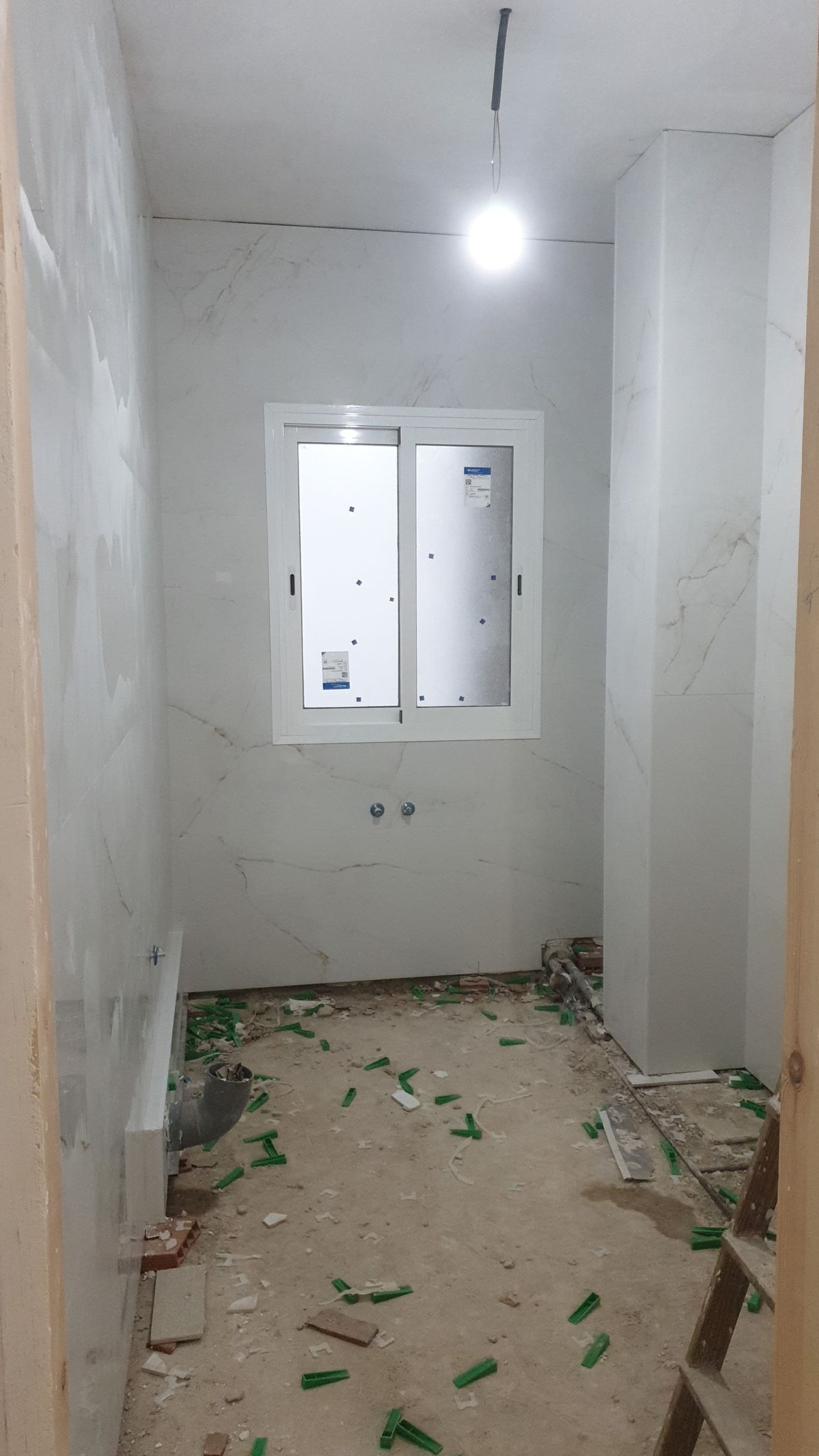 Una habitación vacía con una ventana y una luz en el techo.