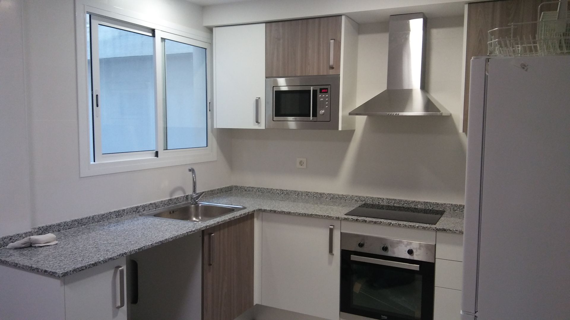 Una cocina con electrodomésticos de acero inoxidable y encimeras de granito.