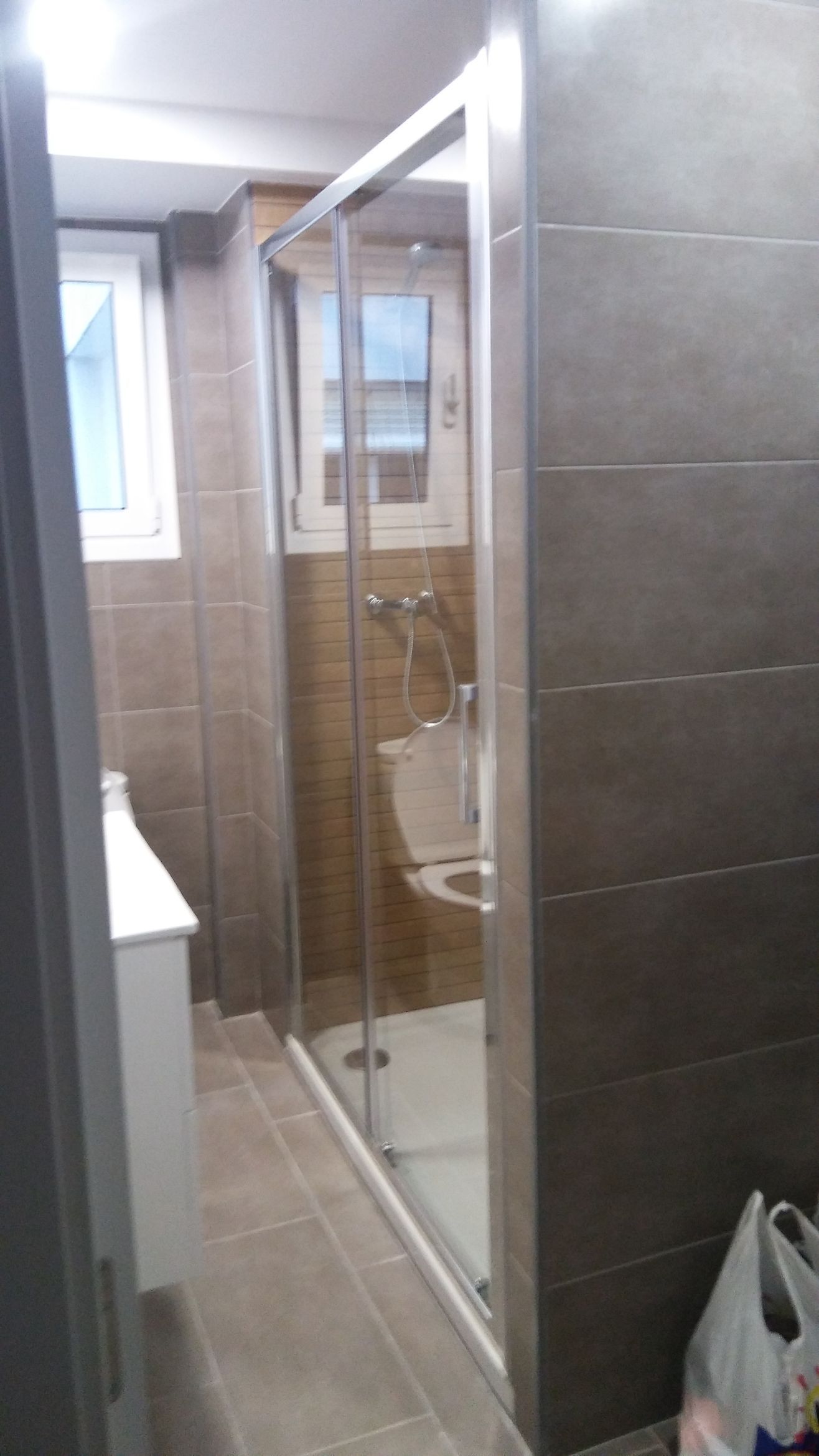 Un baño con puerta de ducha corrediza de cristal y un inodoro.