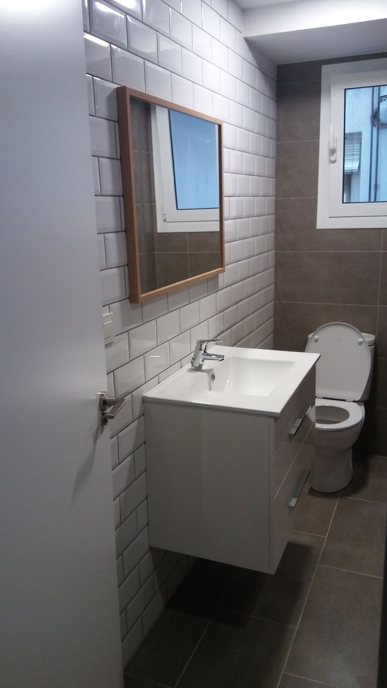 Un baño con lavabo, inodoro y espejo.