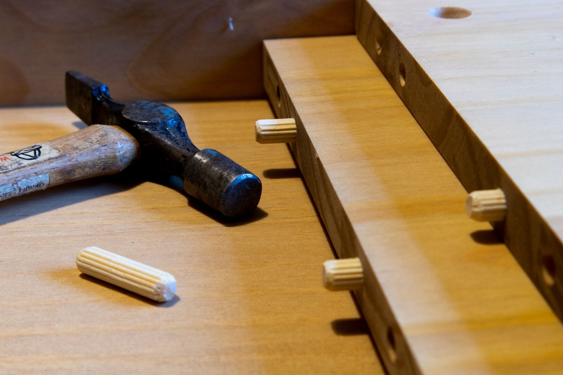 Una mesa de madera con un martillo y tacos encima.
