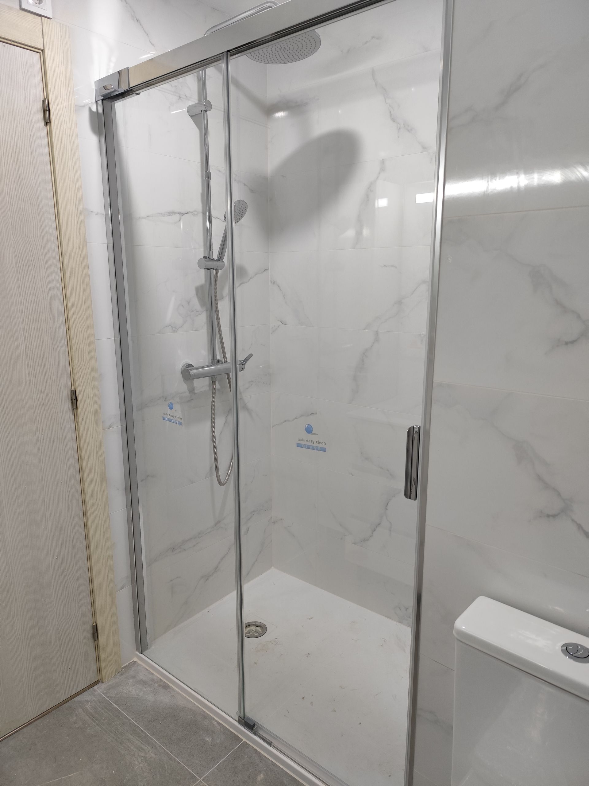 Un baño con puerta de ducha corrediza de cristal y un inodoro.