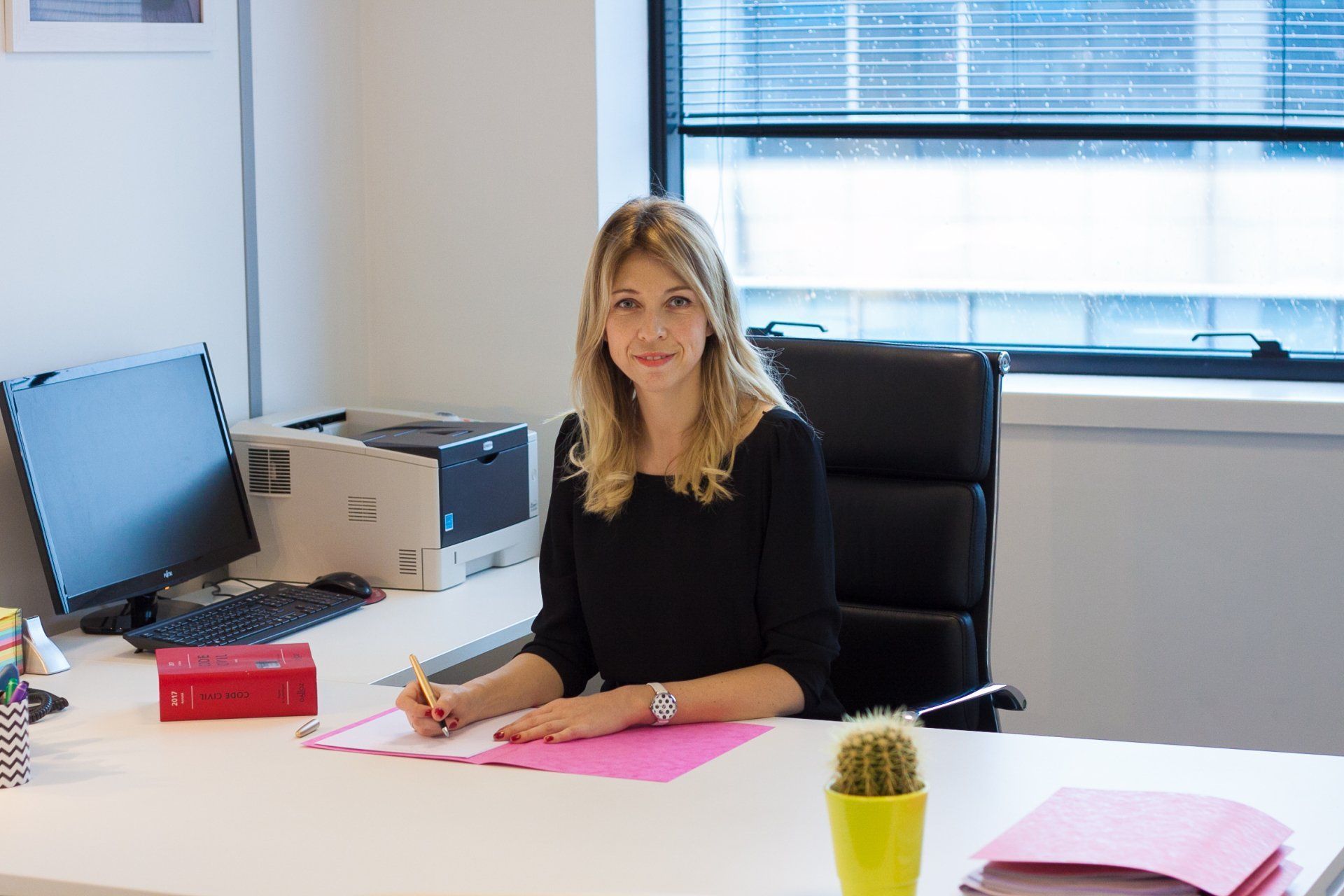 Une femme assise Me. Jeannot, à son bureau écrit. Environnement de bureau.