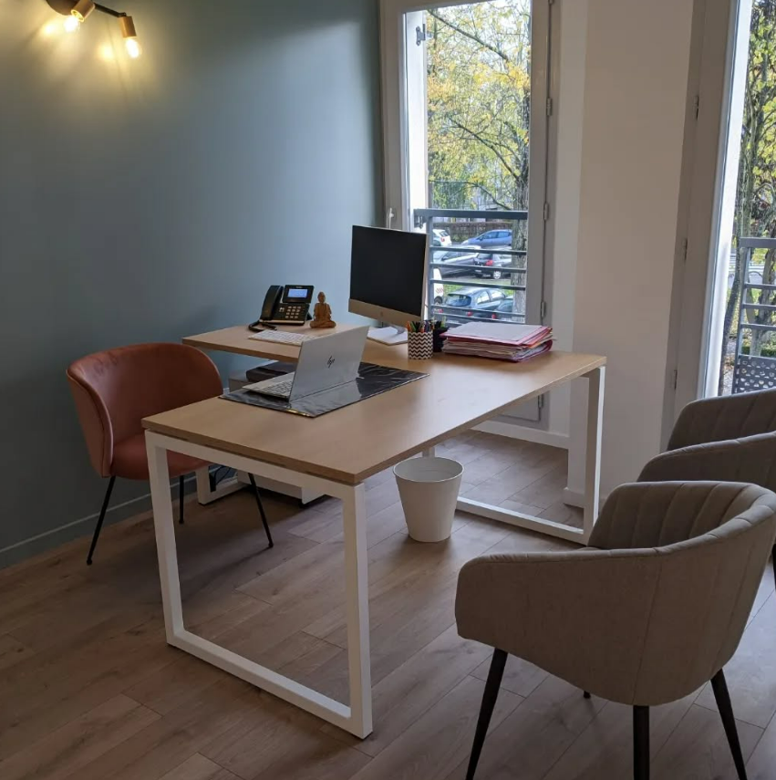 Bureau avec mobilier, ordinateur et deux chaises ; vue sur l'extérieur.
