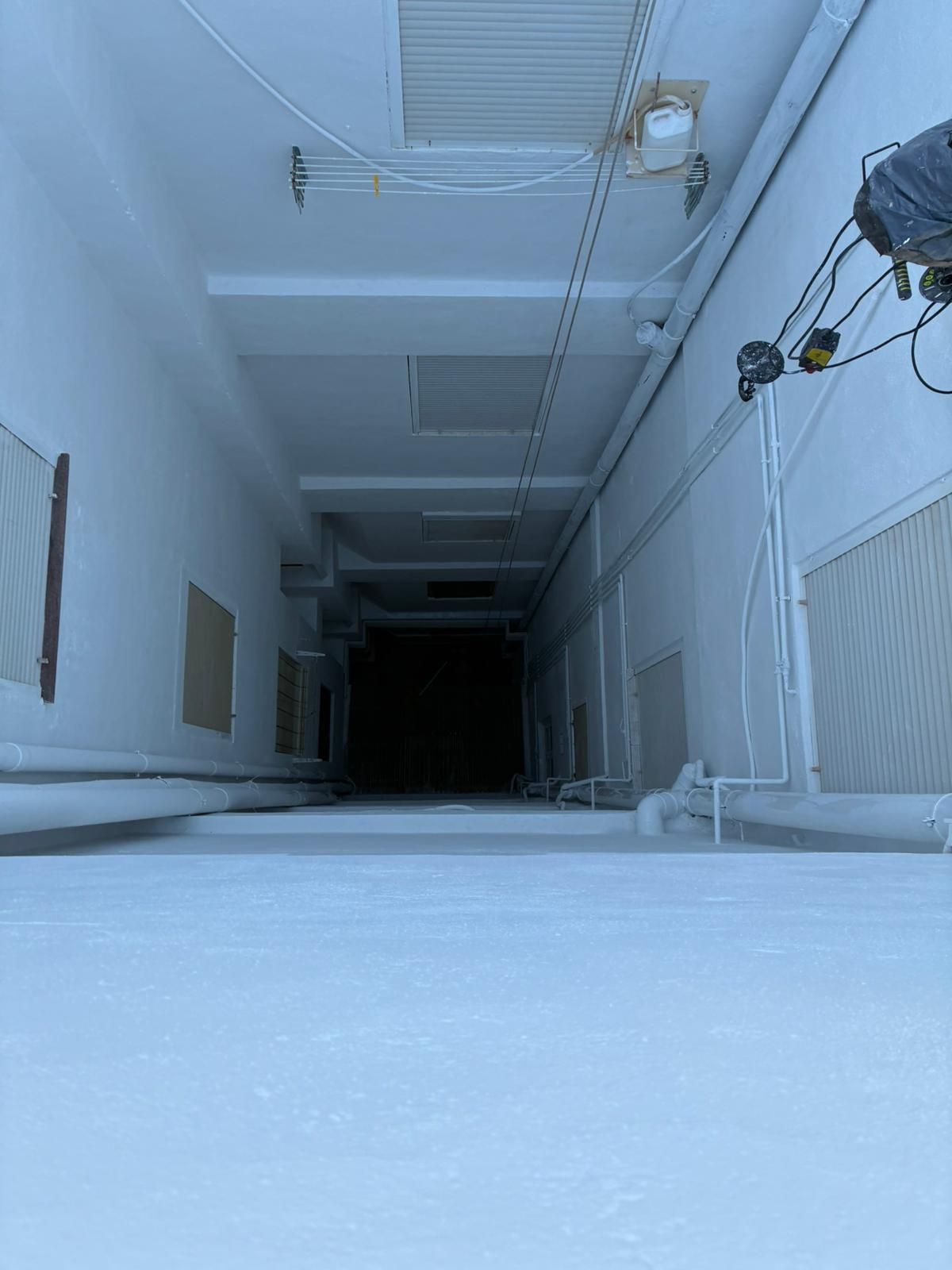 Persona suspendida de una cuerda trabaja en una estructura cerca del agua; lleva un casco