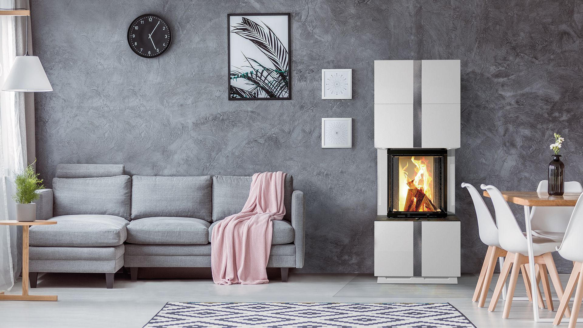 Salon moderne gris avec canapé, horloge murale, cheminée et table à manger près de grandes fenêtres