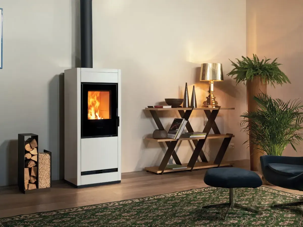 Salon moderne avec un poêle à bois blanc, des bûches empilées, des étagères décoratives et une plante verte sur un tapis
