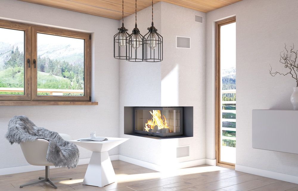 Salon moderne avec cheminée allumée, grandes fenêtres et fauteuil blanc à côté d'une petite table.