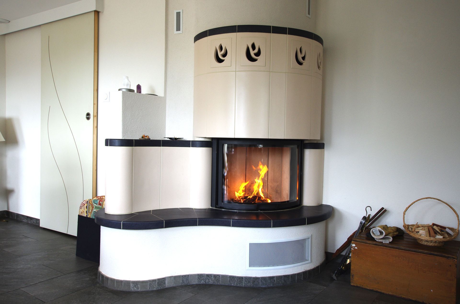 Cheminée blanche incurvée moderne avec un feu qui brûle dans une pièce simple