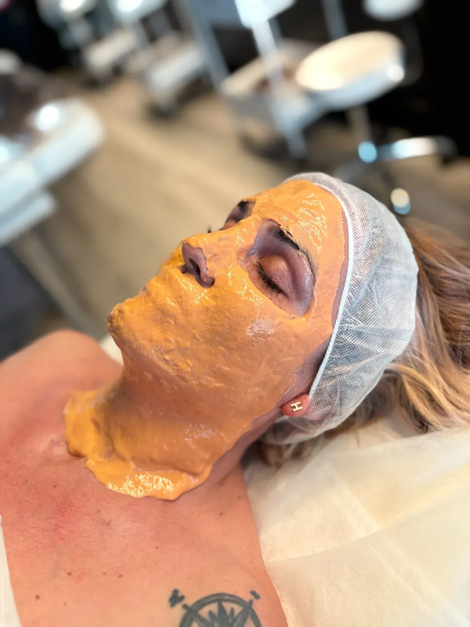 Una mujer está acostada en una cama con una máscara en la cara.