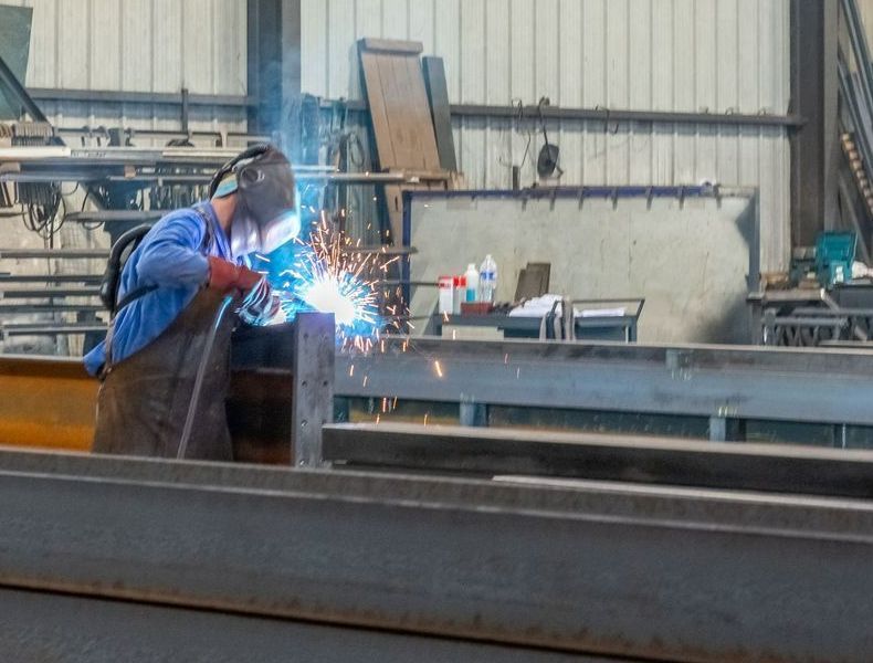 Professionnel soudant une pièce métallique en atelier