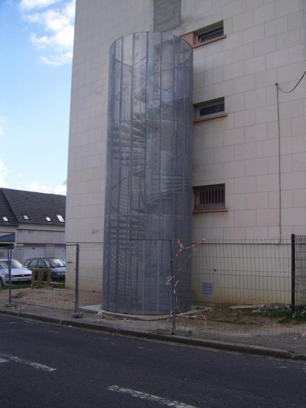 Extérieur de façade avec un escalier en colimaçon et garde-corps métallique