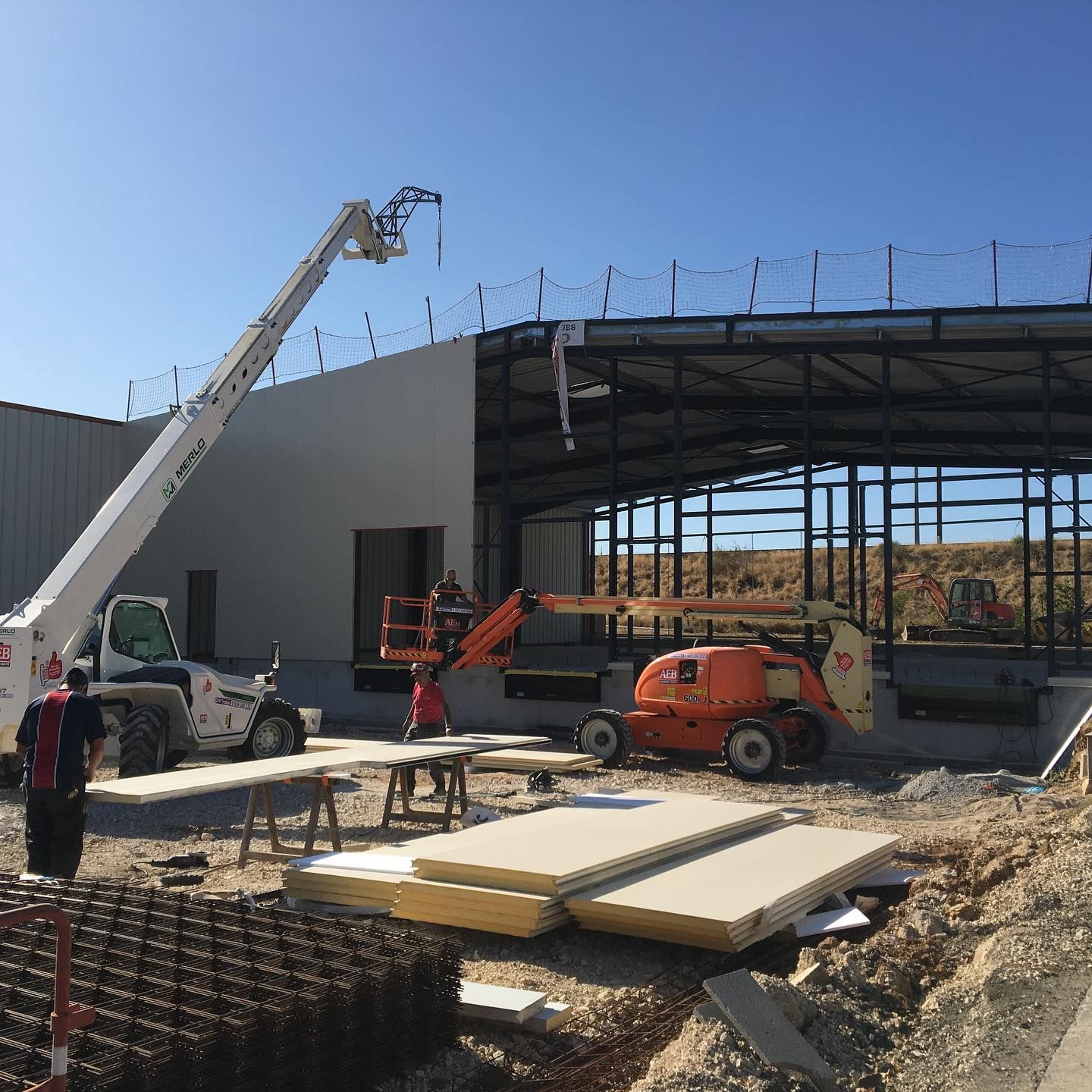 Chantier de pose de bardage en métal à l'aide d'une grue