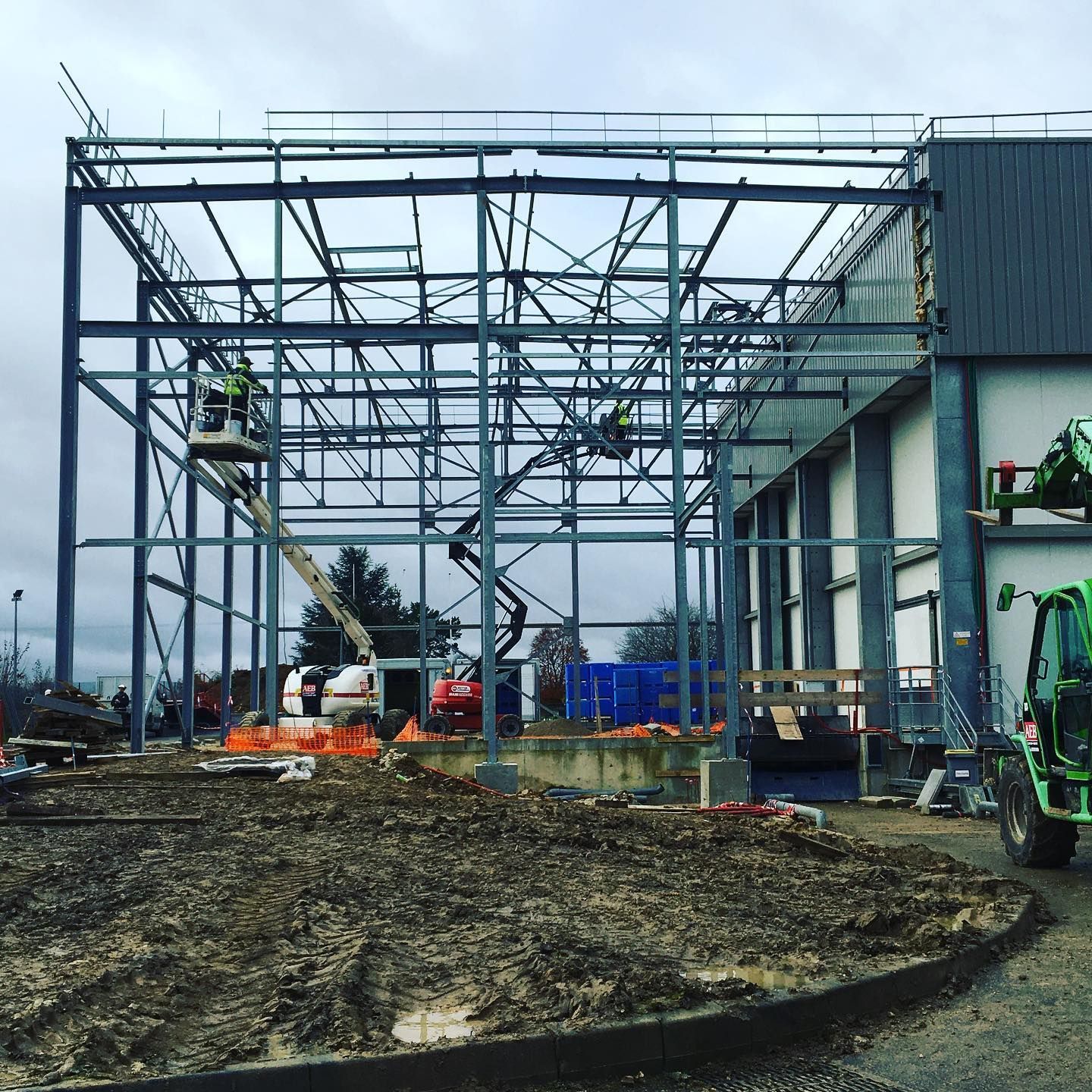 Chantier d'assemblage d'une extension en métal attenante à un entrepôt