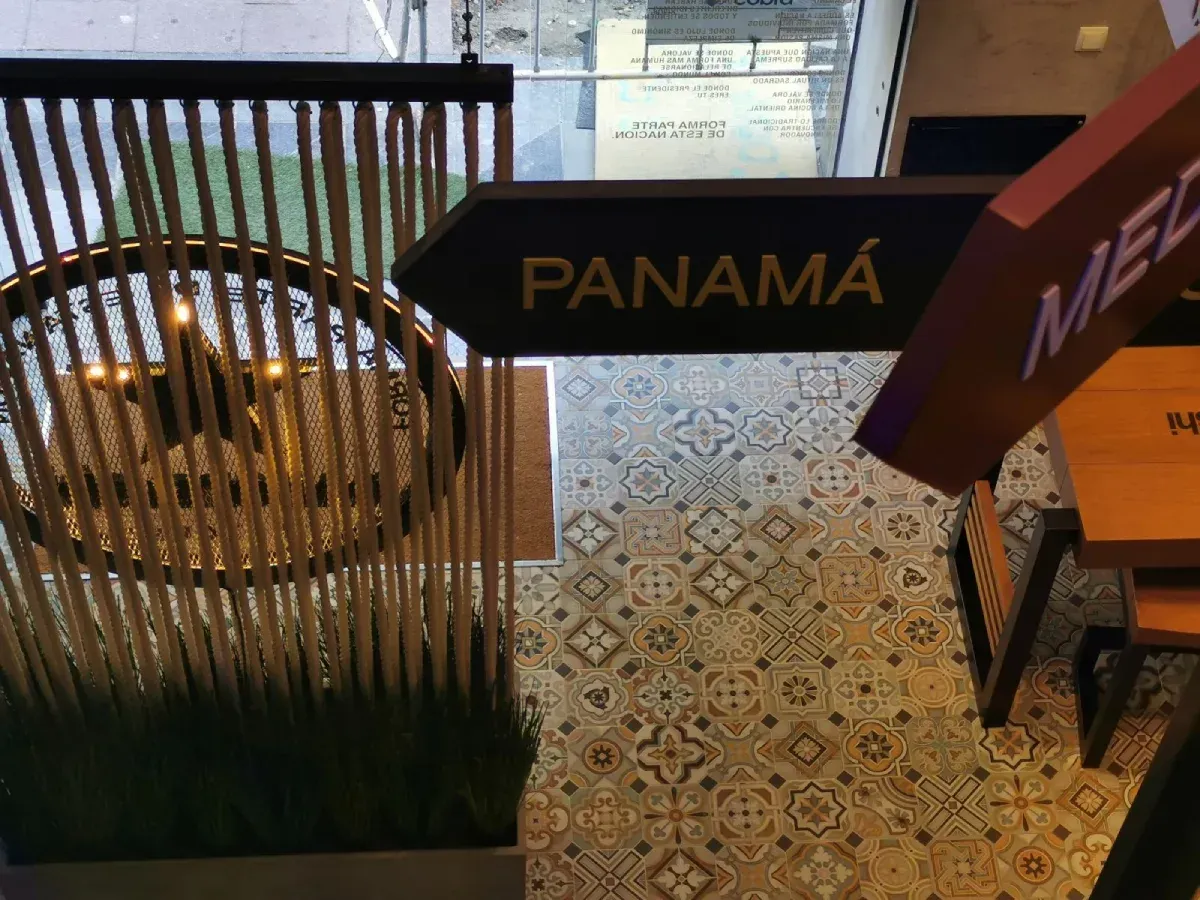 Letreros de Panamá y México sobre un piso de baldosas estampadas en un espacio interior.