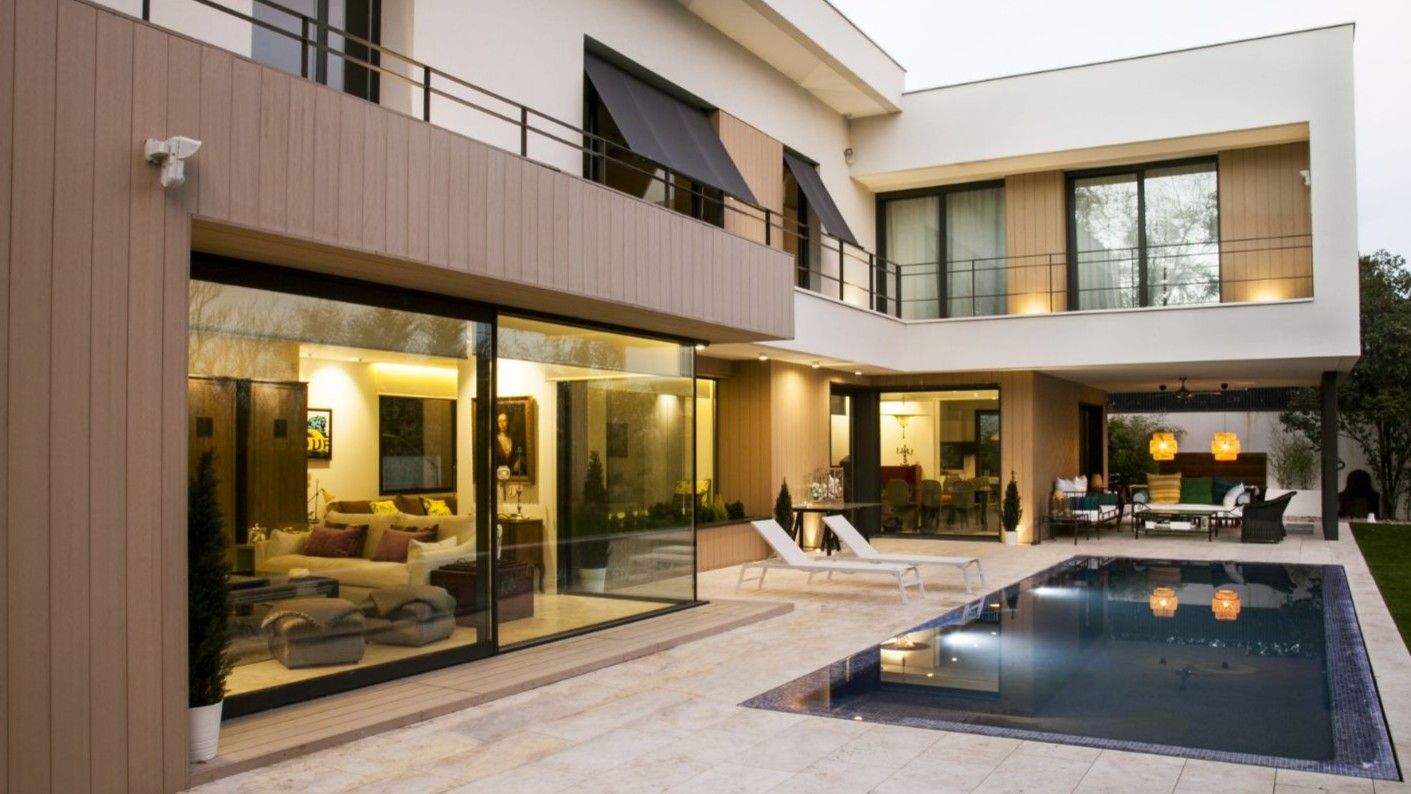 Una casa grande con piscina delante de ella.