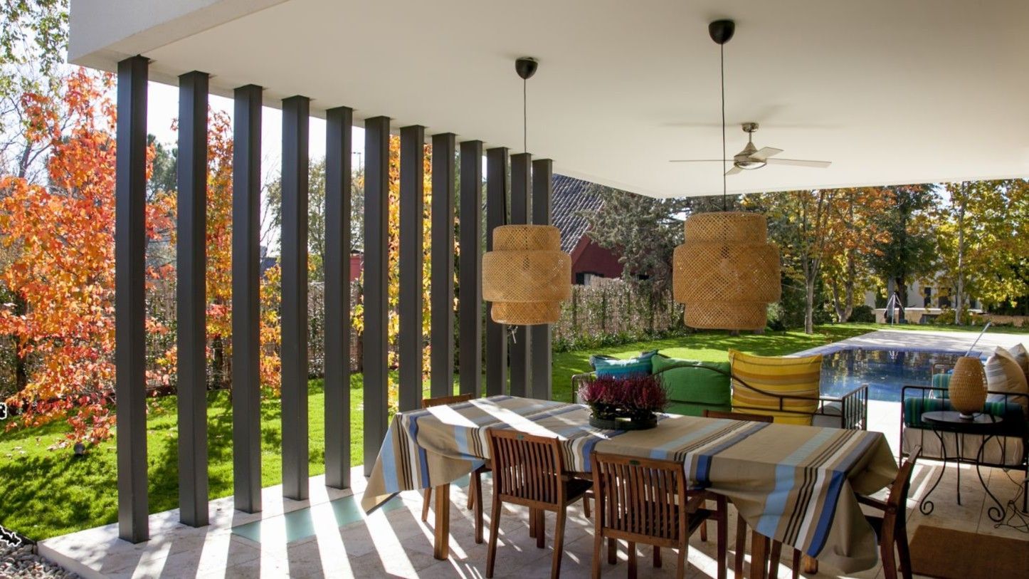 Un patio con mesa y sillas y un ventilador de techo.
