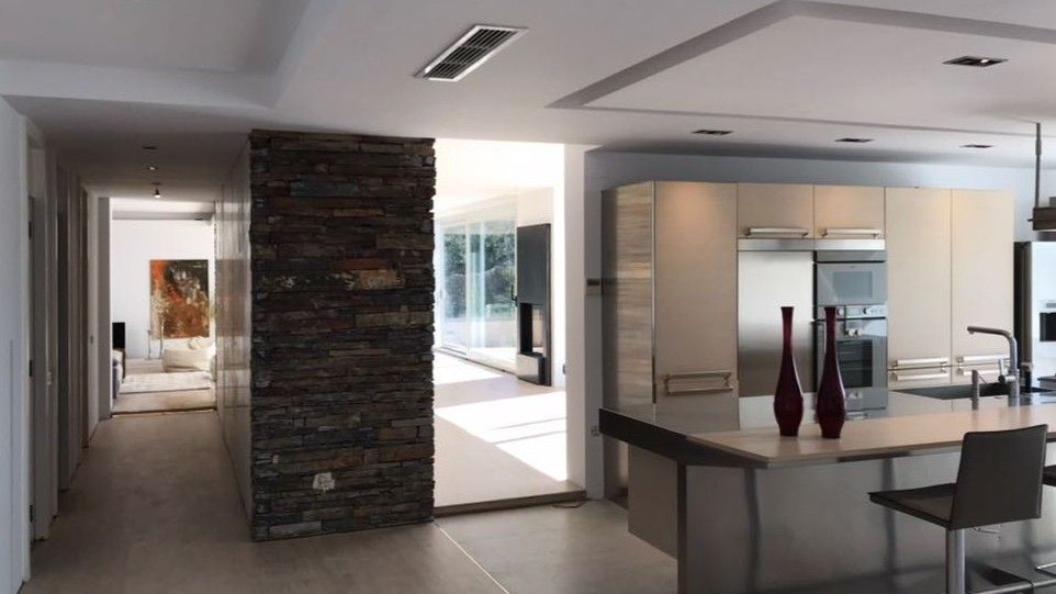 Una cocina con gabinetes blancos y electrodomésticos de acero inoxidable.