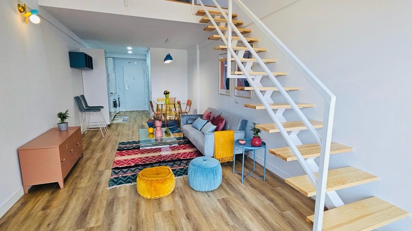 Una sala de estar con una escalera que conduce al segundo piso.
