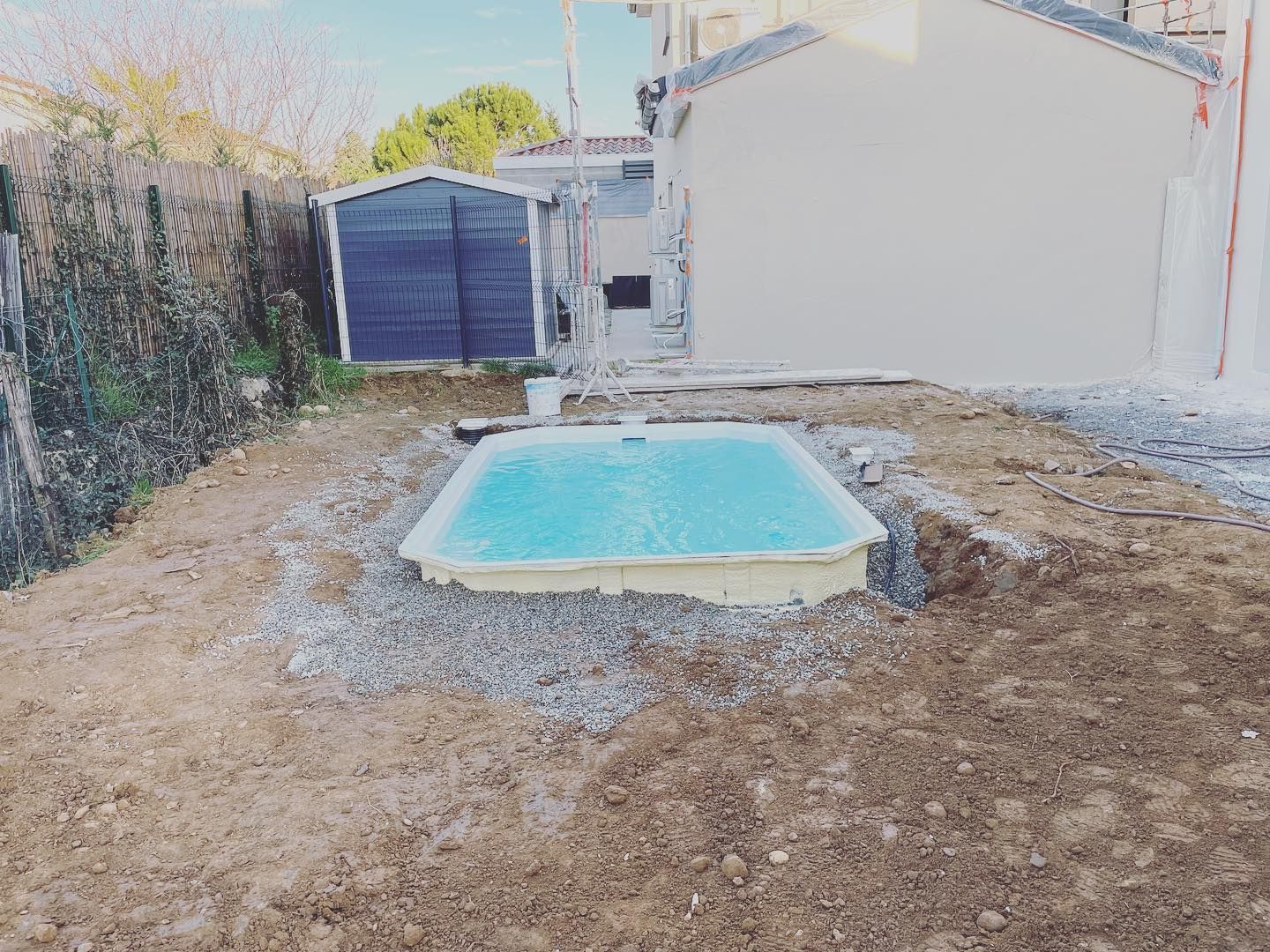 Une piscine à coque creusée à l'arrière d'une maison