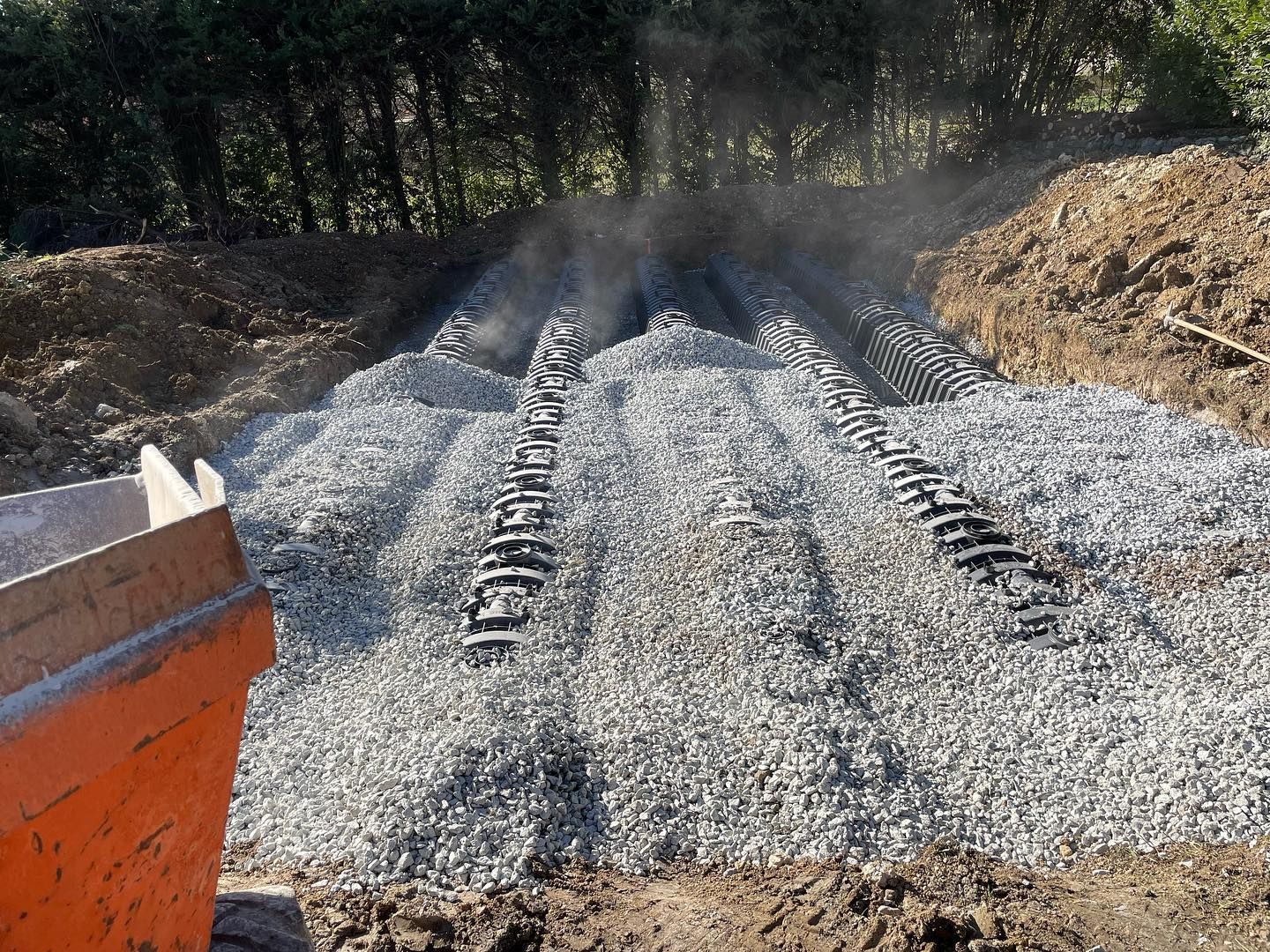Terrain rempli de citernes noires recouvertes de graviers