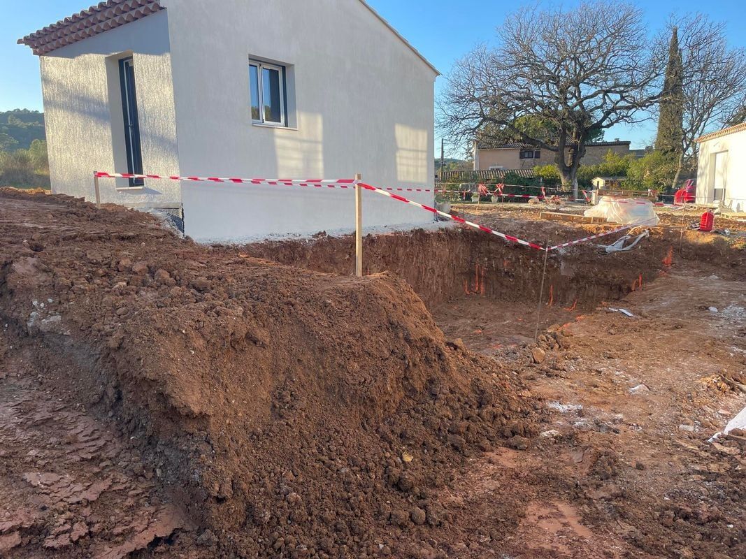 Jardin en travaux de terrassement, le long d'une maison
