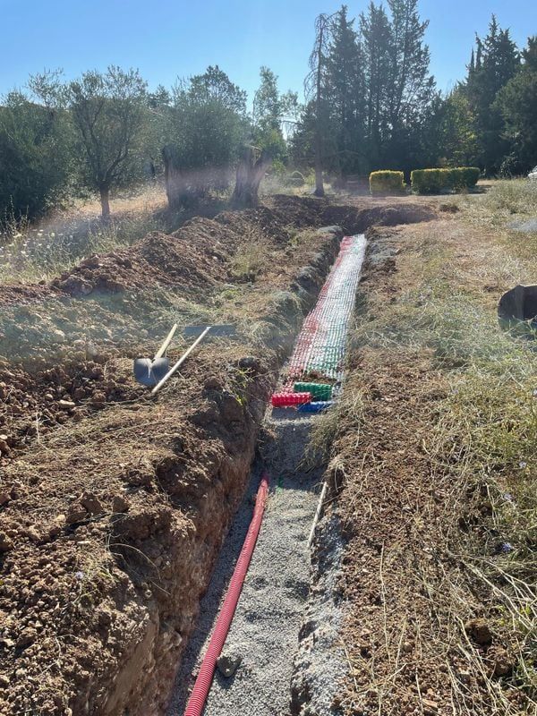 Une tranchée dans un champ en train d'être rebouchée