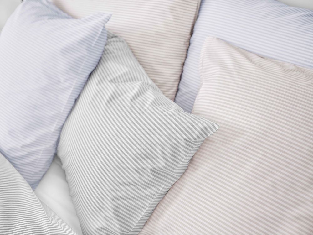 Auf einem Bett liegen mehrere Kissen übereinander.