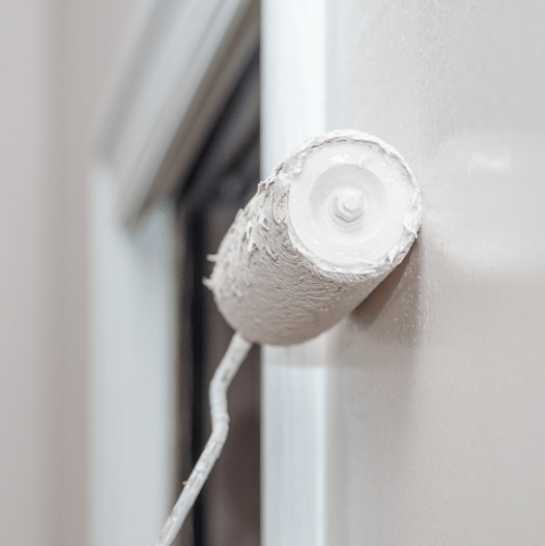 Persona con gorra midiendo persianas con cinta y lápiz cerca de una ventana.